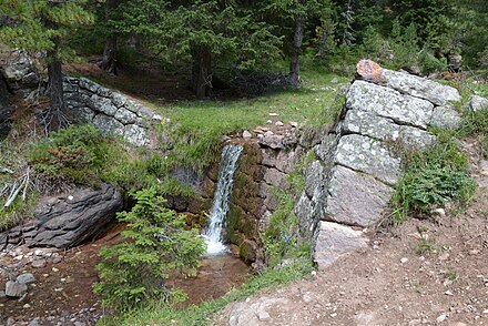 During periods of high river flow, this nineteenth century weir of porphyry stone on a creek in the Alps would have significantly more water flowing over it.