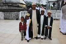 Un homme et ses enfants devant la grande mosquée de Mbéni