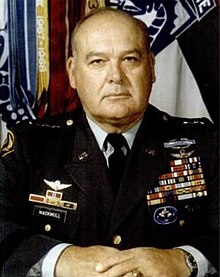 1981 head and shoulders color photo of Lieutenant General Jack V. Mackmull in dress uniform, seated at desk, hands folded in front