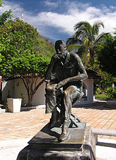 Fotografie a statutului lui John Huston: el stă, îngândurat