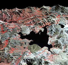 A false colour satellite image of Laguna del Maule, a lake with an irregular shape within mountains