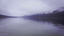 Vue d'un lac avec du brouillard en arrière-plan.