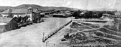 The "Old Plaza Church" facing Los Angeles Plaza, 1869. The brick reservoir in the middle of the Plaza was the original terminus of the Zanja Madre