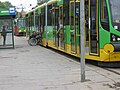 Polski: Tramwaj Moderus Beta MF 02 AC (#415) w Poznaniu na przystanku "Bałtyk" - osoba niepełnosprawna wsiada do tramwaju. English: Tram Moderus Beta MF 02 AC (#415) in Poznań at the "Bałtyk" stop - disabled person gets on the tram.