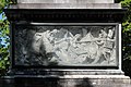 Français : Bas-relief sur la facelatérale du piédestal, derrière une vitre sale.