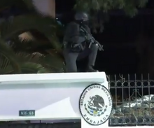 Un policía ecuatoriano entrando por la barda de la embajada mexicana en Quito.