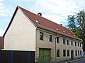 Rural residential building with courtyard passage and cellar with large barrel (field stone) in closed development, at right angles courtyard wing and barn (field stone) with extension (brick)