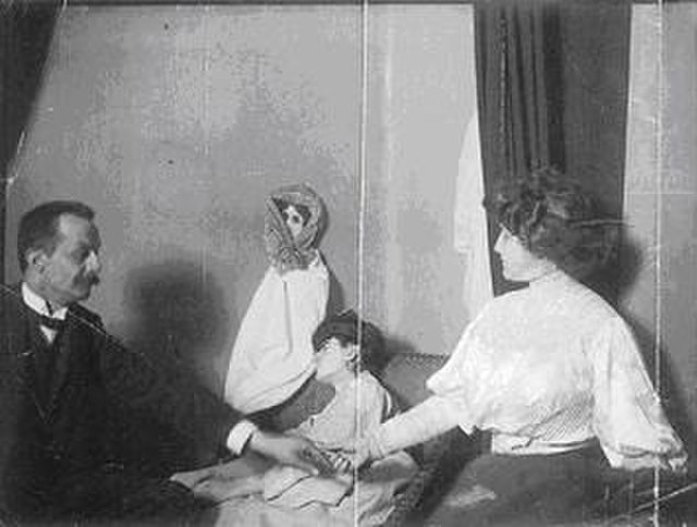 A photograph of the medium Linda Gazzera with a doll as fake ectoplasm