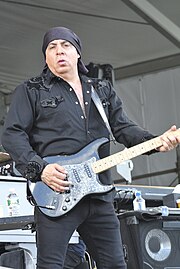 A man on stage holding a guitar