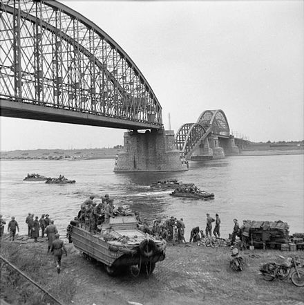 DUKWs transport supplies across the River Waal at Nijmegen, below the railway bridge whose central span was broken by German frogmen using floating mines, 28 September 1944