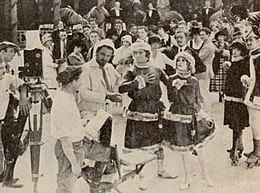 Still of Geldart (left foreground) portraying a casting director organizing an ice-skating routine in The Goat (1918)