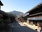 Pequeña calle bordeada por casas de madera de dos pisos.