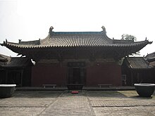 The Wanfo Hall of Zhenguo Temple. The tiled roof is decorated with small, ornate dragons. There is one door opening to a bricked courtyard