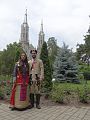 Двойка с вингански носии на фона на църквата.