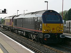 Zwei Lokomotiven der Baureihe 67 vor einem Güterzug. Die Vordere trägt die Farben des Royal Train