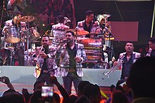 Banda MS performing at the Feria de Cholula, in 2016. Banda MS Cholula.jpg