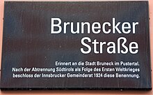 Street sign in Innsbruck, Tyrol, commemorating the city of Bruneck, set up in 1923 in response to the prohibition of the original southern Tyrolean place names. Brunecker Strasse - Innsbruck.jpg