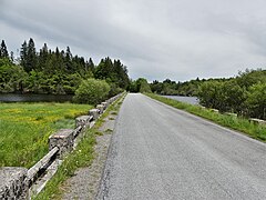 La RD 992 passe au-dessus du lac de Faux.