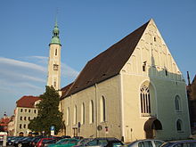 Barevná fotografie s pohledem na pozdně gotický kostel se štíhlou věží