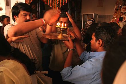 Taking arti blessing during a Durga puja celebration.
