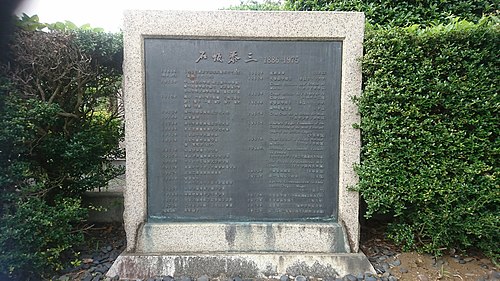 墓の横にある石碑には、泰三の功績が年表で記されている Wikipediaより