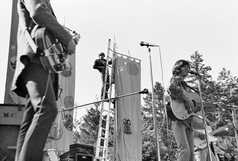 The Lamp of Childhood plays while a stagehand attends to a backdrop banner KFRC Fantasy Fair backdrop.png