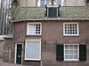 Tegen kooromgang van de kerk aan gebouwd huis met dak