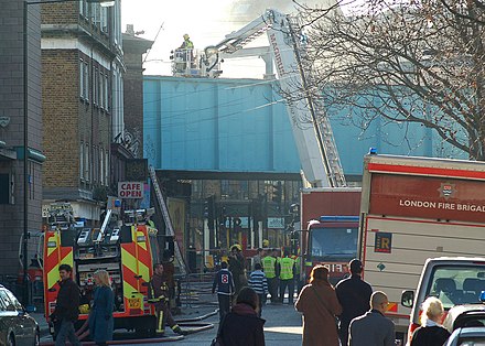Damping down using an aerial ladder platform after a fire in Camden