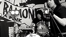 Marky on drums with Ken Stringfellow singing into a microphone