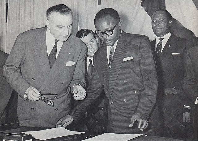 Maurice Yaméogo, the first president of Upper Volta, examines documents pertaining to the ratification of the country's independence in 1960