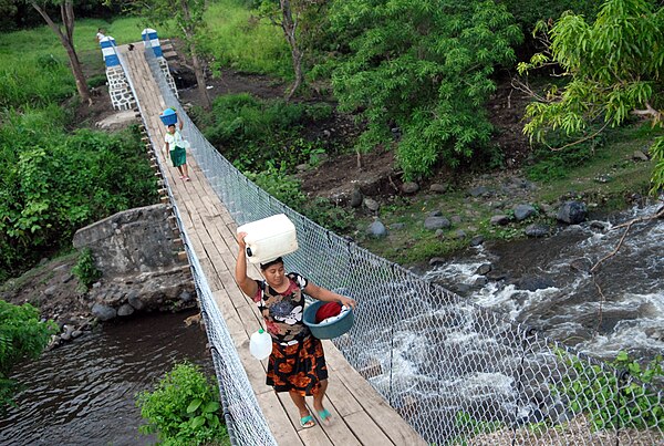 Women heading to market across a footbridge in Nahulingo, El Salvador