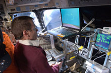 Johnson uses the Portable In-Flight Landing Operations Trainer (PILOT) on the flight deck of the Earth-orbiting Space Shuttle Atlantis during the STS-125 mission STS-125 FD11 sim.jpg