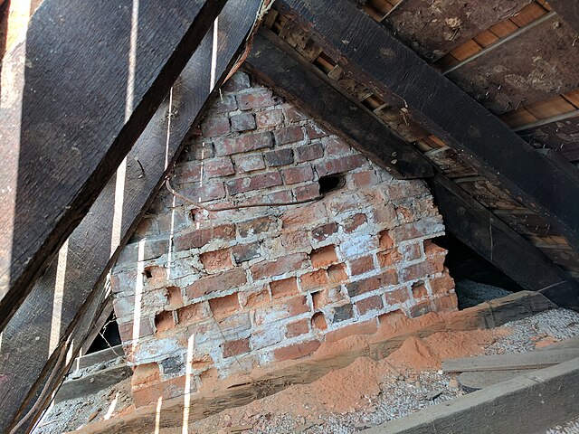 Spalling of brick in an 18th century chimney. The lower section is older than the upper. Note that the while the lower mortar is deteriorated, it is n