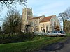 Een stenen kerk gezien vanuit het zuidoosten met trapgevels, ook met de zuidelijke kapel, veranda, lichtbeuk en versierde toren