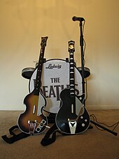 A set of The Beatles: Rock Band instrument controllers - a Hofner 500/1 "violin bass" controller, a Gretsch Duo Jet guitar controller, a Ludwig drum set and a microphone with its stand. The Beatles Rock Band - Complete Set.jpg