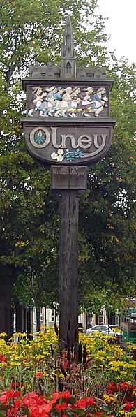 Olney town sign, depicting a women's pancake race