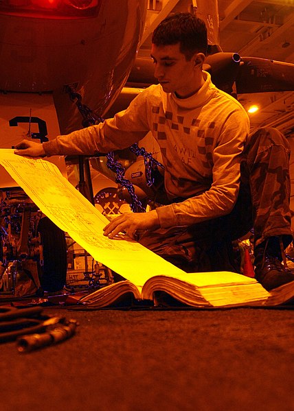 File:US Navy 050113-N-3644C-001 Aviation Structural Mechanic 1st Class Adam Rocks studies a wire diagram during maintenance on an E-2C Hawkeye.jpg