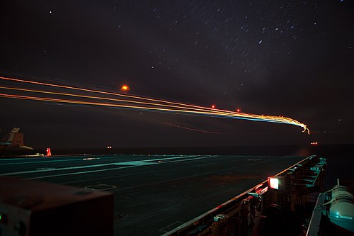 Two streaks of light, representing advancing technology and the passing of time, in a night sky. The world is advancing technology to new heights. (and also trying to move past COVID-19)