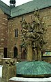 The Narrenbrunnen statue in the Marketplace in Buchen (Neckar-Odenwald-Kreis, Baden-Württemberg), Germany showing various characters of the Buchener Faschenacht (Buchen carnival) above a fountain representing three wells (turned off for winter). The characters include the Erbsenstrohbär (pea-straw bear) and the Huddelbätz, with pointed hats and costumed in strips of coloured rags or ribbons, who wear bells and make loud noises to drive out evil spirits. In the foreground is the legendary figure of the "Blecker", who dates from a time when Buchen was beseiged. As their food began to run out, the inhabitants decided to give it all to one man. Once he was fattened up, they displayed him, naked, on top of the walls. The sight of such a fat rump persuaded the attackers that the townspeople obviously still had plenty of food in reserve, so they gave up and retreated.