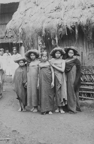 File:COLLECTIE TROPENMUSEUM Portret van een groep Batak meisjes in een dorp met een aantal mannen op de achtergrond TMnr 60043402.jpg