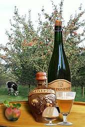 Foto, das Apfelwein-, Apfelwein- und Calvados-Produkte im Rahmen einer bepflanzten Wiese darstellt