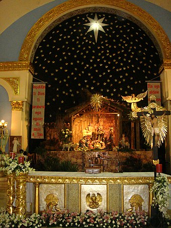 A Belén set up in the altar of the Candon Church in the Philippines with a parol above it