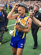 Dom Sheed, who kicked the winning goal, with the premiership cup after the grand final Dom Sheed with the premiership cup 2018 AFL Grand Final.jpg