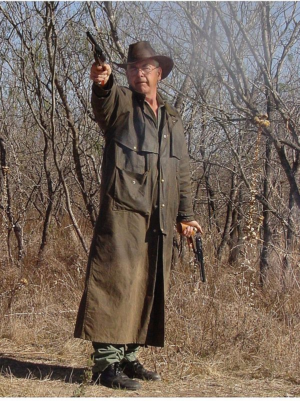 A cowboy action shooter brandishing his revolver