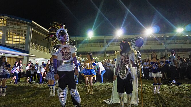 Two mascots standing in Father Saturnino Urios University at night