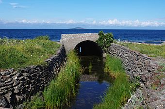 Sjöns utflöde i nordväst. I fjärran skymtar Blå Jungfrun.