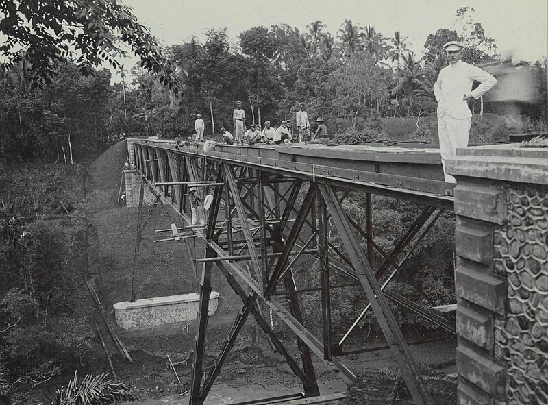File:Indische arbeiders op een afgebouwde brug over de Kali Brantas ten zuiden van Malang, op de voorgrond een Europeaan aangeduid als 'de Heer Van Leeuwen' (Photo XXI), RP-F-F01114-U.jpg