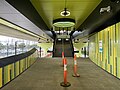 The mid-level concourse with the stairs leading to the platforms and main concourse, looking north, July 2024