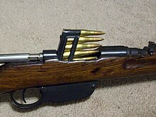 Um clipe em bloco calibre 8×56mmR é inserido em uma carabina Steyr M95.
