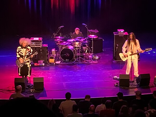 Melvins live in Knoxville, Tennessee, June 2022. Left to right: Buzz Osborne, Dale Crover (behind drum kit) and Steven Shane McDonald.